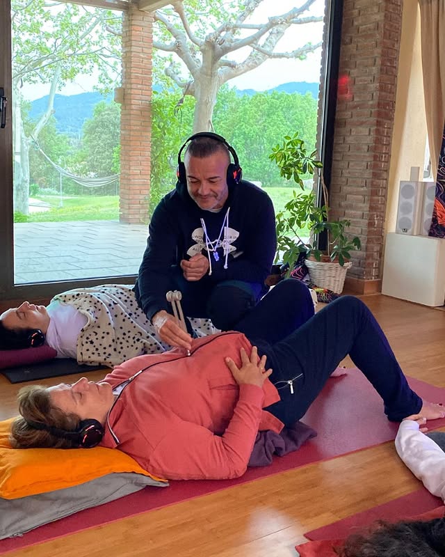 Facilitador asistiendo a participante en sesión energética.